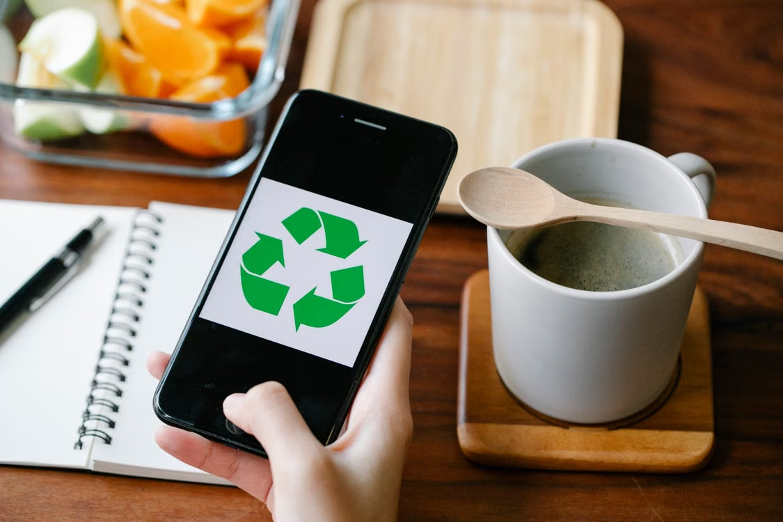 person-using-recycling-app-on-smartphone-against-coffee-7262405